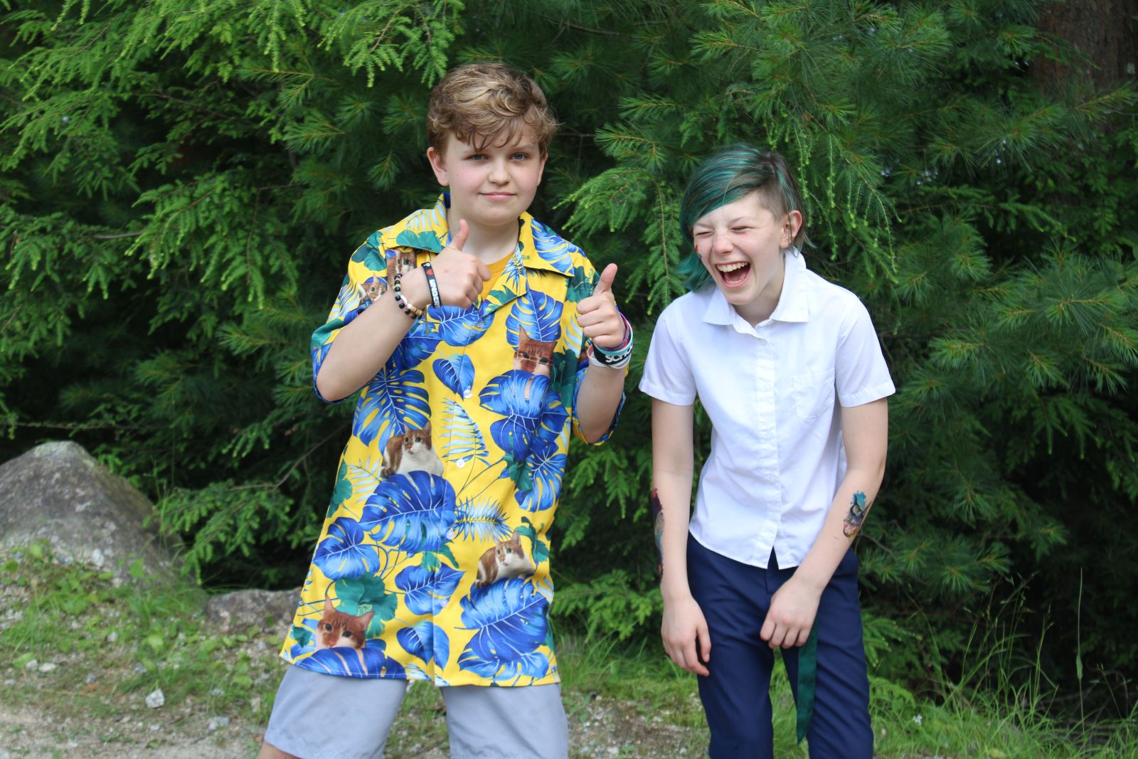 Two campers, one in a bright colored shirt with images of blue leaves and cat is